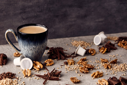 a cup of Ola coffee surrounded by Ola home compostable capsules, nuts and seeds